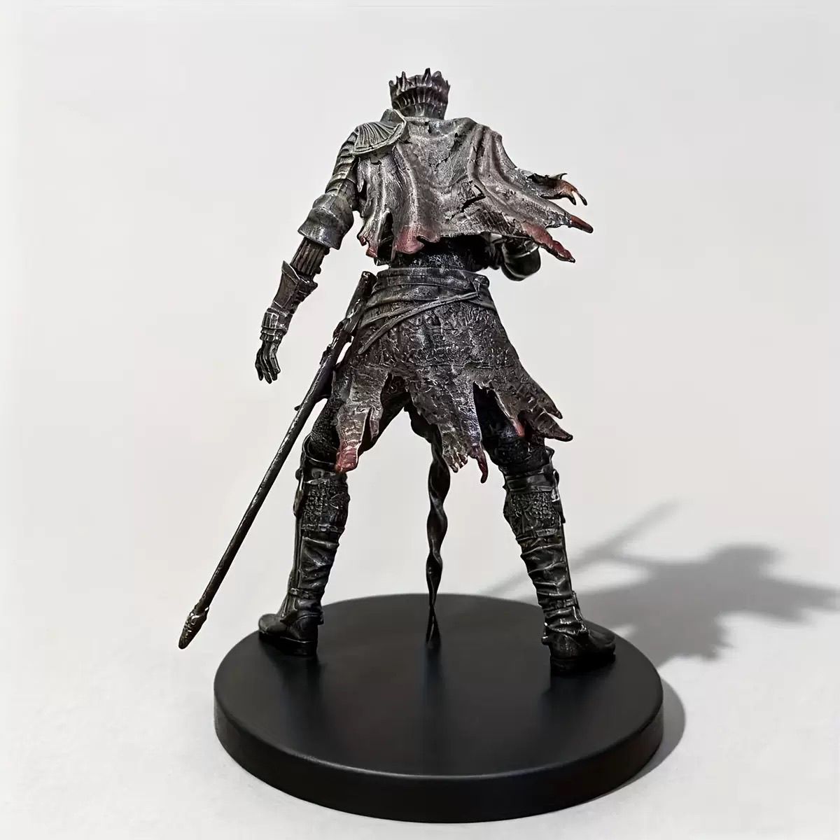 Rear view showing the weathered cape and armor details of the knight figure
